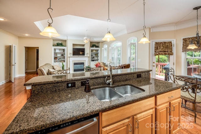 7245 Willow Brook Ct, Denver, NC 28037 - kitchen featuring a sink, ornamental molding, a glass covered fireplace, dishwasher, and dark stone counters