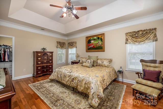 7245 Willow Brook Ct, Denver, NC 28037 - bedroom with a raised ceiling, a walk in closet, wood finished floors, baseboards, and crown molding