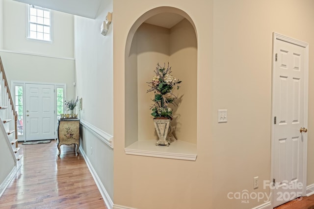 7245 Willow Brook Ct, Denver, NC 28037 - hall featuring stairway, wood finished floors, baseboards, arched walkways, and a towering ceiling