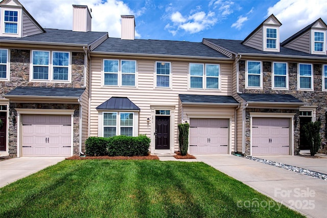 view of property featuring stone siding, driveway, a front lawn, and a garage