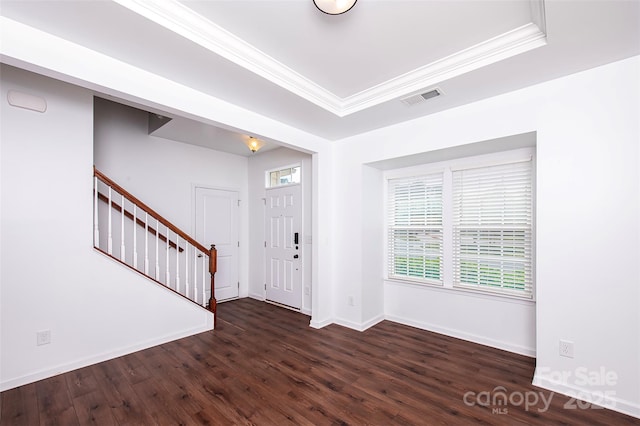 foyer with crown molding, dark wood-type flooring, stairway, baseboards, and a tray ceiling