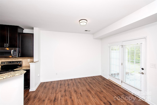 kitchen with stainless steel appliances, dark wood-type flooring, light stone counters, backsplash, and baseboards