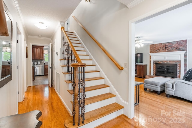 2730 Tiffany Dr, Rock Hill, SC 29732 - stairs featuring wood finished floors, a ceiling fan, crown molding, and a brick fireplace