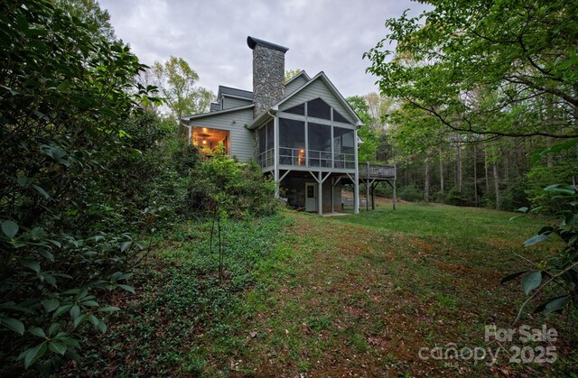 4398 Mud Puddle Ln, Lenoir, NC 28645 - rear view of house with a sunroom, a chimney, and a yard