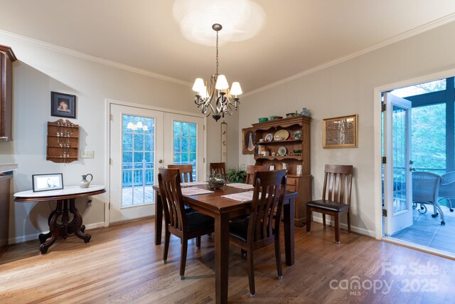 4398 Mud Puddle Ln, Lenoir, NC 28645 - dining room featuring light wood-type flooring, a chandelier, ornamental molding, baseboards, and healthy amount of natural light