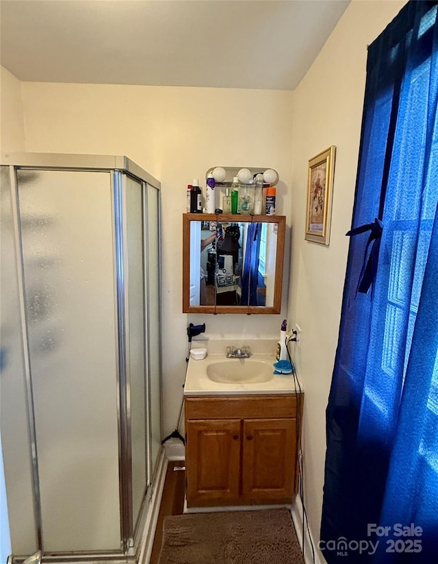 bathroom with a shower stall and vanity