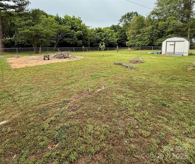 view of yard featuring a storage shed, an outdoor fire pit, and an outbuilding