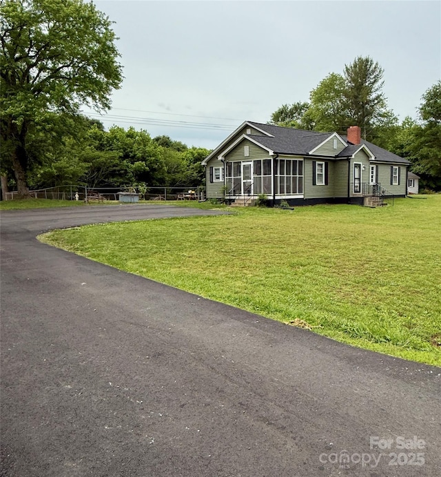 view of front of house featuring a chimney and a front lawn