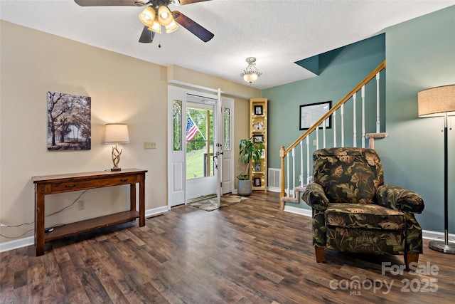 foyer featuring wood finished floors, baseboards, stairs, and a ceiling fan