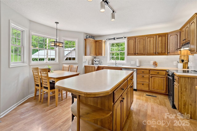 kitchen with black range with electric stovetop, stainless steel dishwasher, under cabinet range hood, light wood finished floors, and a textured ceiling