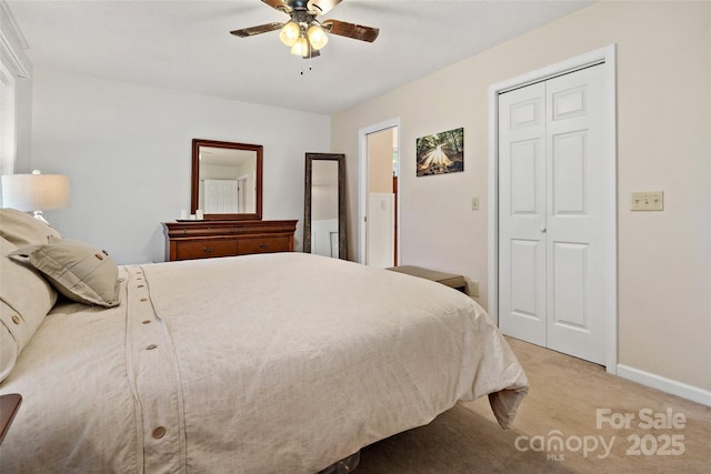 bedroom with light carpet, a closet, baseboards, and a ceiling fan