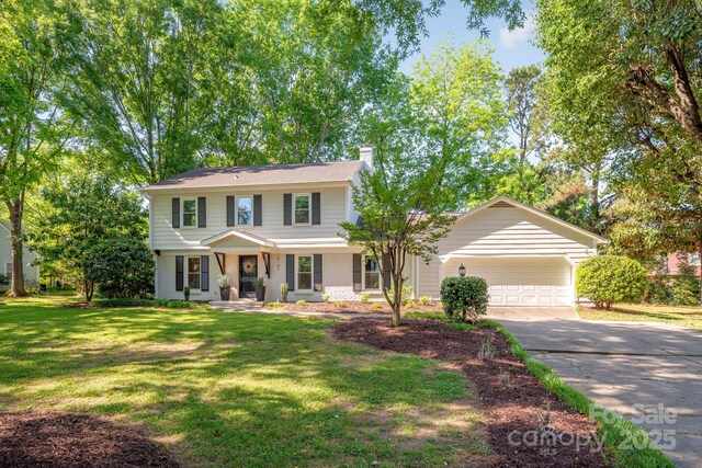 3101 Willowbrae Rd, Charlotte, NC 28226 - view of front of house with a chimney, asphalt driveway, a garage, a front yard, and covered porch