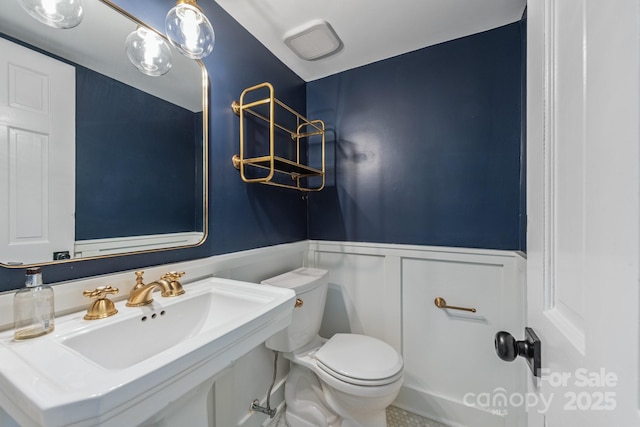3101 Willowbrae Rd, Charlotte, NC 28226 - bathroom with wainscoting, toilet, a sink, and a decorative wall