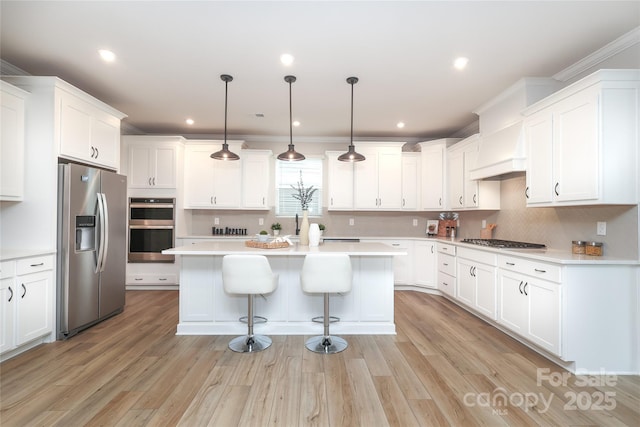 1119 Bellshill Dr, Indian Trail, NC 28079 - kitchen with appliances with stainless steel finishes, premium range hood, a center island, white cabinetry, and ornamental molding