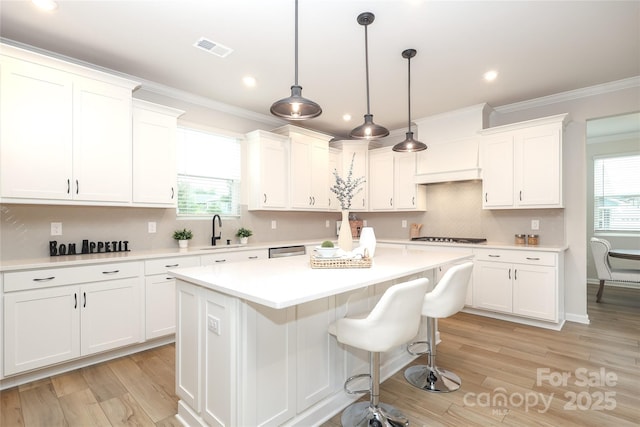 1119 Bellshill Dr, Indian Trail, NC 28079 - kitchen featuring white cabinetry, a center island, light countertops, a sink, and ornamental molding