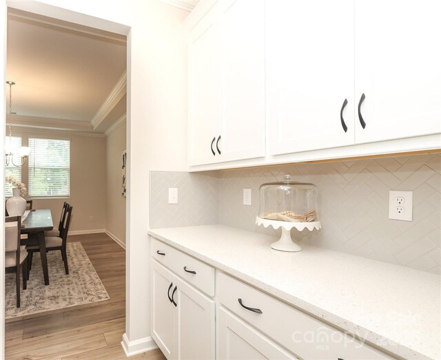 1119 Bellshill Dr, Indian Trail, NC 28079 - kitchen with ornamental molding, light wood finished floors, white cabinets, and backsplash