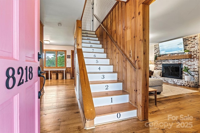 8218 Bright Water Ln, Denver, NC 28037 - staircase featuring a brick fireplace and hardwood / wood-style flooring