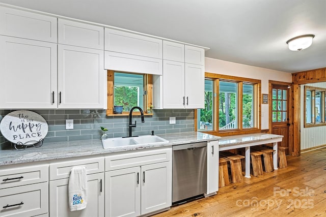 8218 Bright Water Ln, Denver, NC 28037 - kitchen featuring stainless steel dishwasher, a sink, light wood-type flooring, white cabinetry, and tasteful backsplash