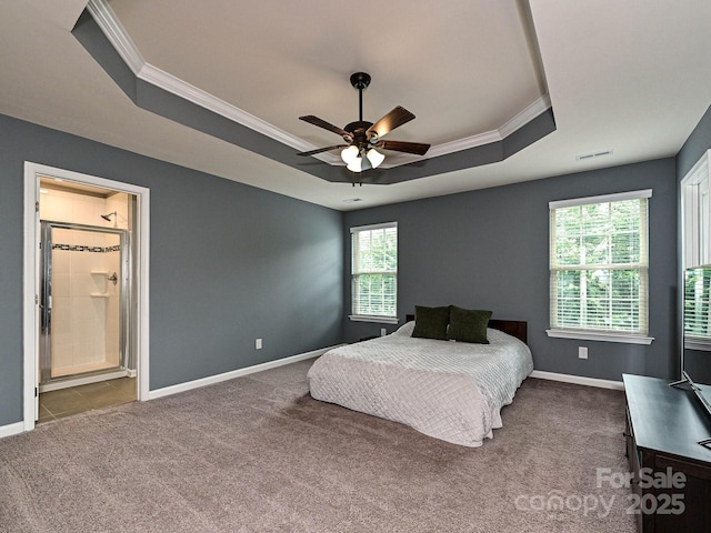 bedroom with a raised ceiling, crown molding, carpet flooring, baseboards, and ensuite bathroom