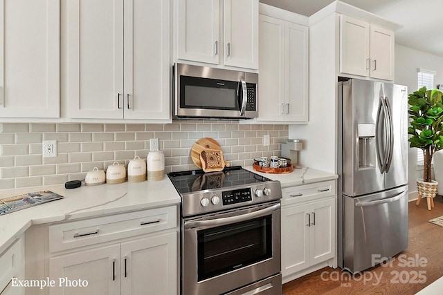 kitchen with appliances with stainless steel finishes, white cabinetry, and decorative backsplash