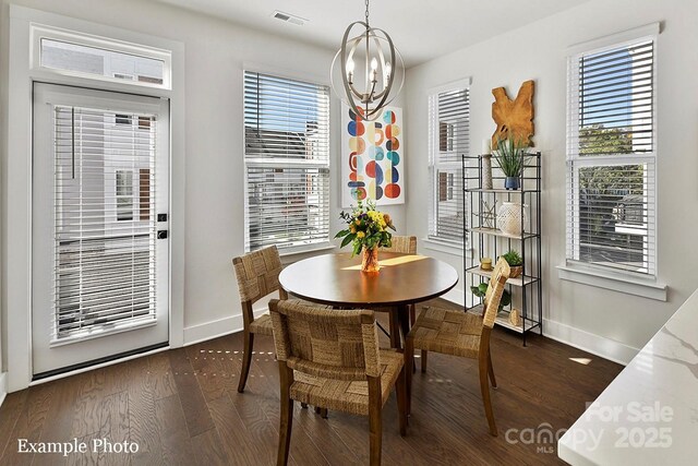 dining space featuring baseboards, a chandelier, and dark wood-type flooring
