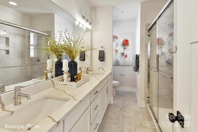 bathroom with a shower stall, toilet, double vanity, baseboards, and recessed lighting