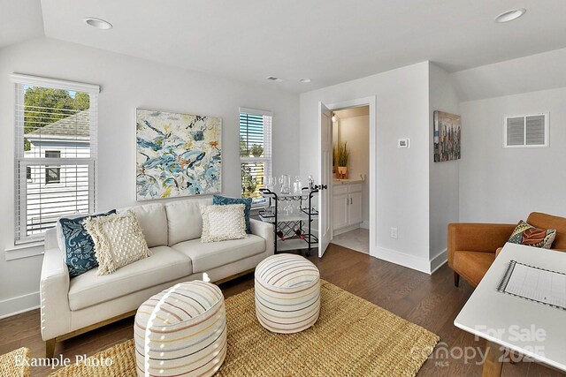 living area featuring healthy amount of natural light, dark wood-type flooring, recessed lighting, baseboards, and lofted ceiling