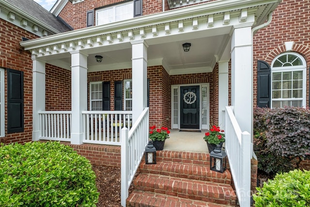 property entrance featuring brick siding and covered porch