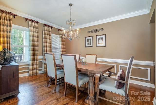 dining room featuring crown molding, wood finished floors, a chandelier, and a wainscoted wall