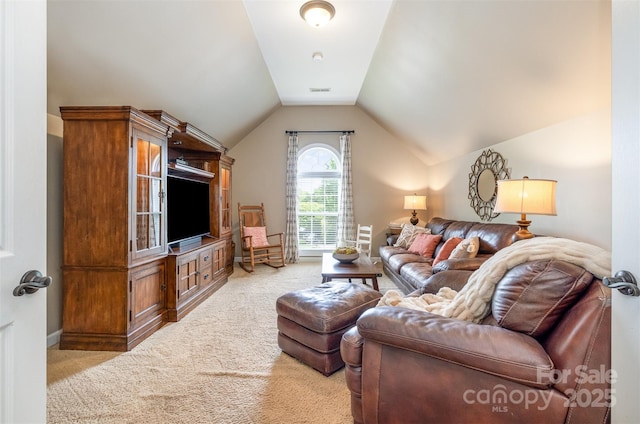 carpeted living area with lofted ceiling and baseboards