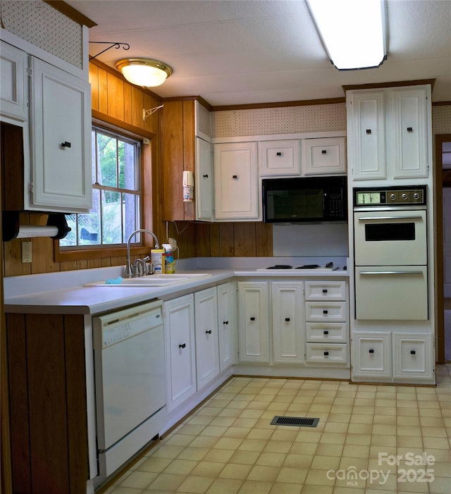 7 Lakewood Rd, Hendersonville, NC 28792 - kitchen featuring white appliances, a sink, white cabinets, light countertops, and wood walls