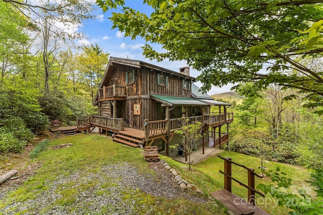 6338 W View Dr, Newland, NC 28657 - back of house with a chimney, a wooden deck, metal roof, and a lawn