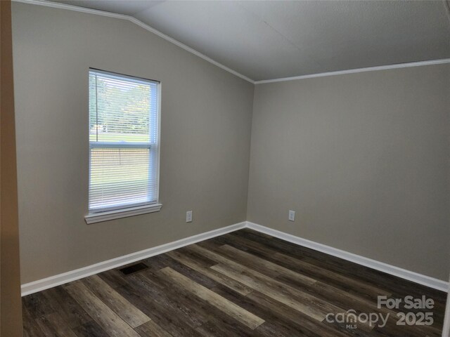 empty room featuring dark wood-style flooring, lofted ceiling, baseboards, and ornamental molding