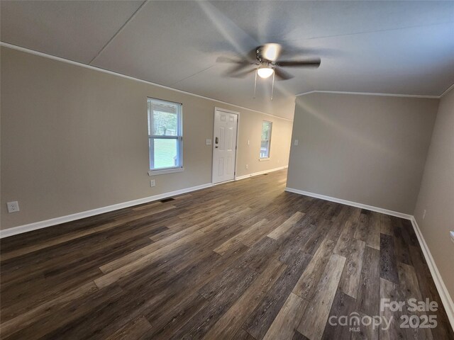unfurnished room featuring a ceiling fan, dark wood finished floors, baseboards, and ornamental molding
