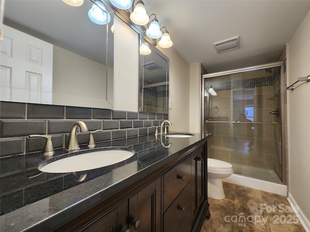 full bath with a shower stall, toilet, double vanity, and tasteful backsplash