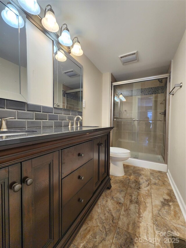 624 Brevard St, Kings Mountain, NC 28086 - full bathroom featuring a stall shower, toilet, double vanity, backsplash, and baseboards