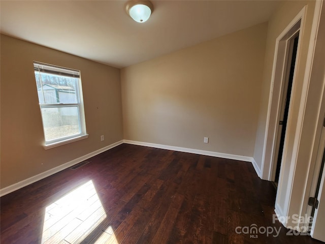 unfurnished room featuring dark wood-style flooring and baseboards