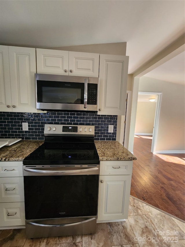 kitchen featuring stainless steel appliances, stone counters, tasteful backsplash, and white cabinets
