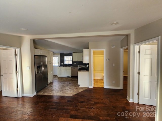 kitchen featuring stainless steel appliances, dark wood-style floors, white cabinets, baseboards, and backsplash