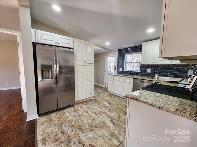 624 Brevard St, Kings Mountain, NC 28086 - kitchen featuring stainless steel appliances, baseboards, light stone counters, white cabinetry, and vaulted ceiling
