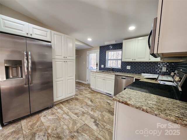 624 Brevard St, Kings Mountain, NC 28086 - kitchen with appliances with stainless steel finishes, light stone counters, tasteful backsplash, white cabinets, and a sink