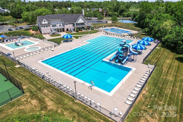 community pool with a water slide, a community hot tub, and a yard