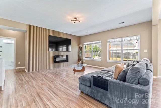 living area featuring wood finished floors, baseboards, and an accent wall