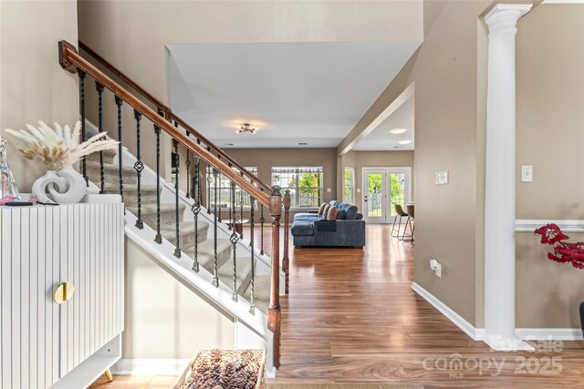 staircase with wood finished floors, baseboards, and french doors