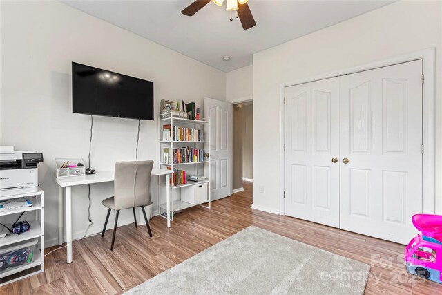 office area with a ceiling fan, wood finished floors, and baseboards