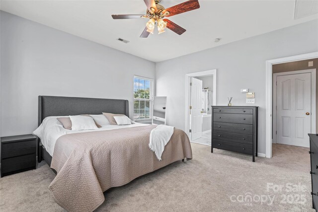 bedroom with light colored carpet, baseboards, a ceiling fan, and connected bathroom
