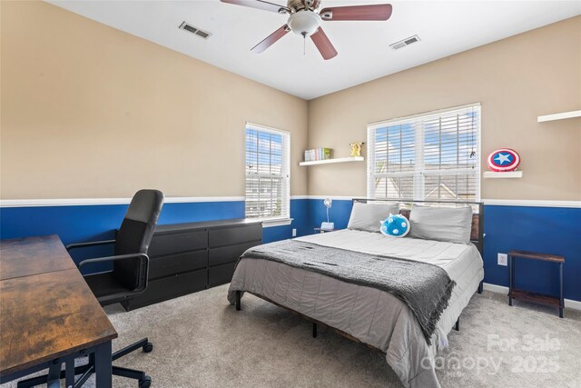 carpeted bedroom with an office area, baseboards, and a ceiling fan