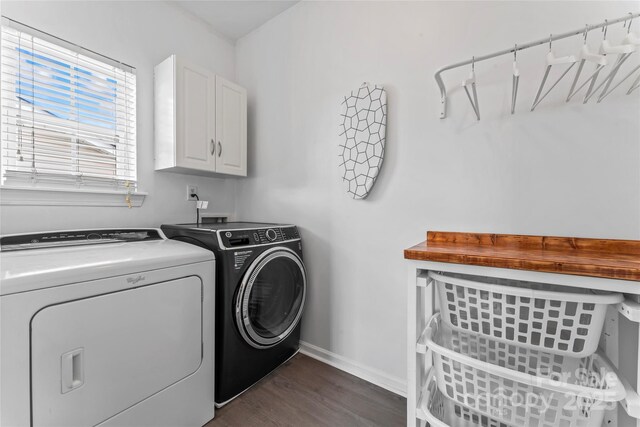 clothes washing area featuring washing machine and clothes dryer, cabinet space, dark wood-style flooring, and baseboards