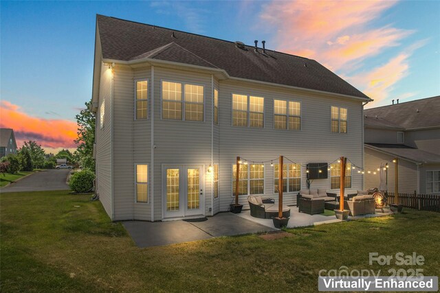 back of house at dusk featuring an outdoor living space, a lawn, a patio area, and central AC