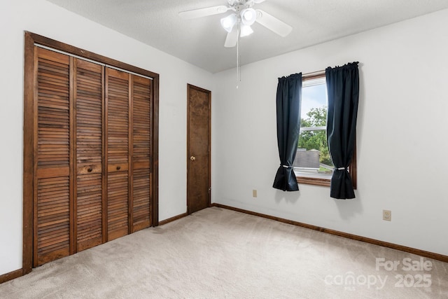 unfurnished bedroom with carpet flooring, baseboards, and ceiling fan